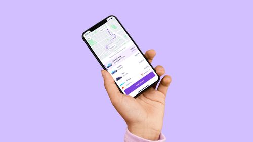 Una mano sostiene un móvil con la app de Cabify