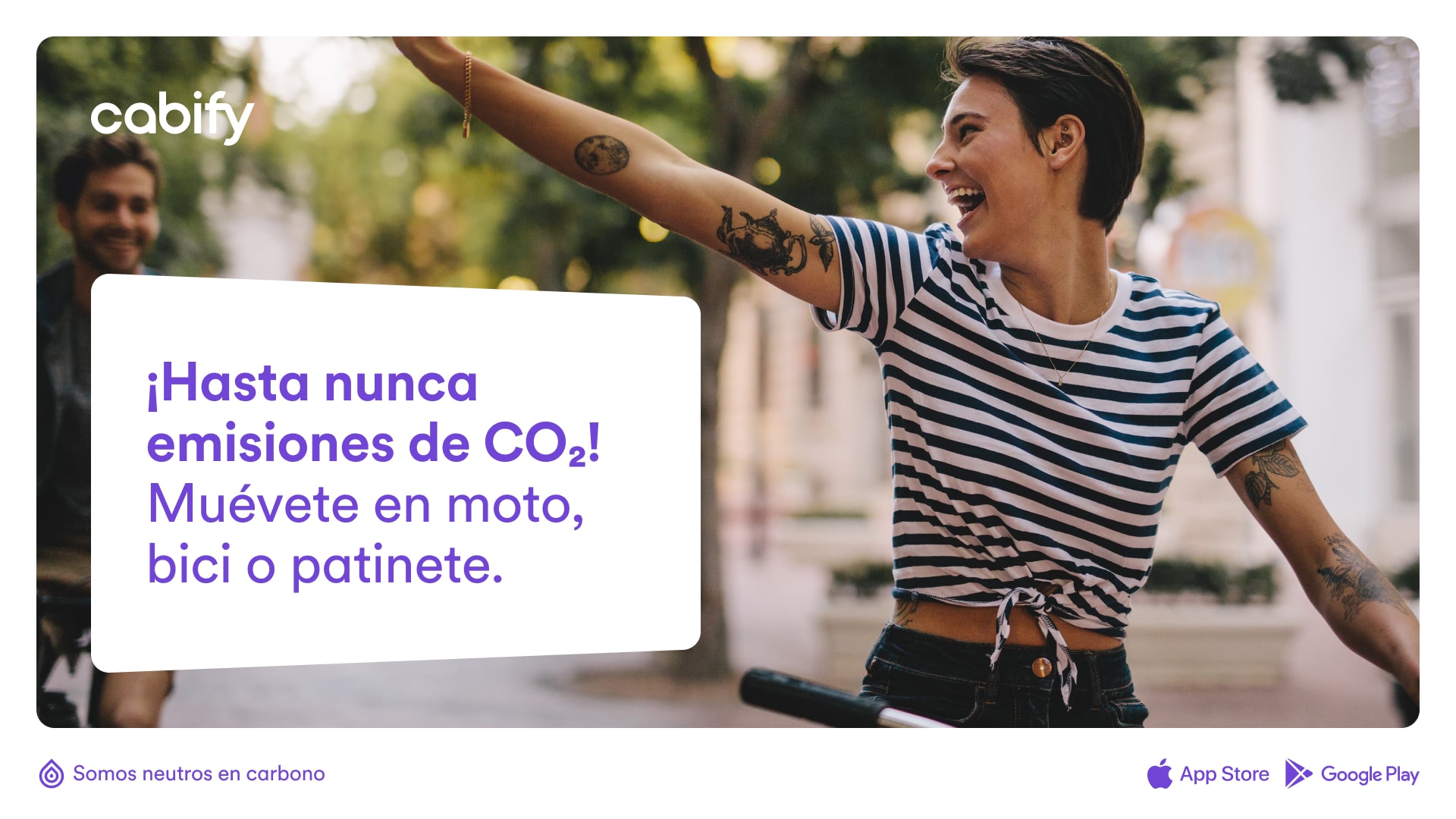 Un anuncio con una foto de una chica en bici y el texto "Hasta nueva emisiones de CO2. Múevete en moto, bici o patinete.